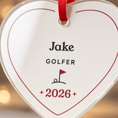 Close-up of the personalized golfer heart ornament showing the name Jake, GOLFER, the golf flag icon and 2026 in red